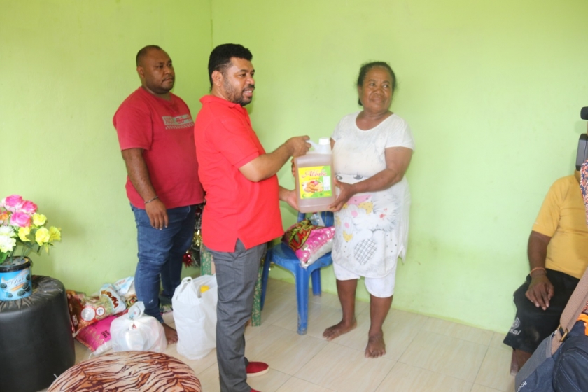 Filep Wamafma menyerahkan bantuan kepada Loisa, istri Stevanus Rosumbre pendiri panti asuhan Kristen Fajar Timur.