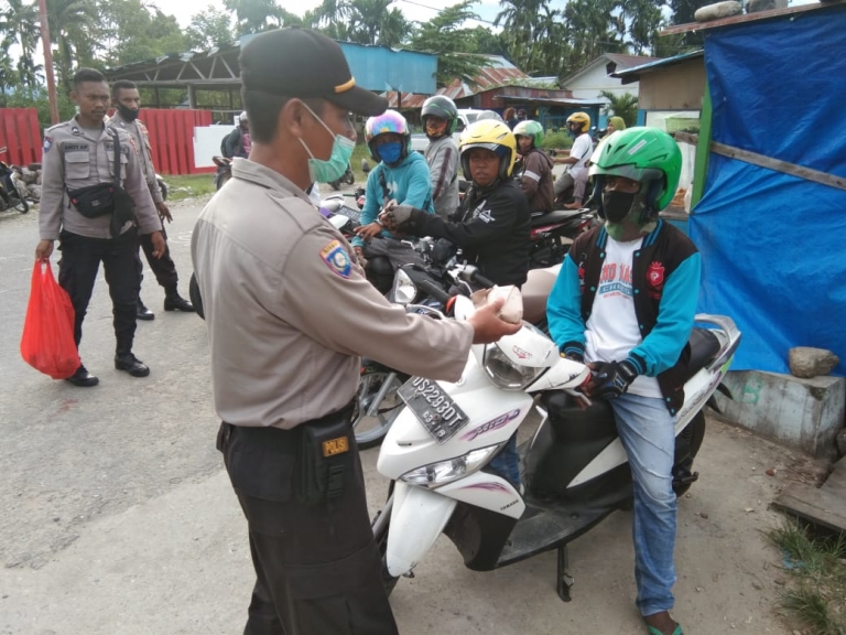 Binmas Polres Teluk Wondama bagikan makanan kepada tukang ojek dan masyarakat yang terdampak Covid-19, Senin (27/4)