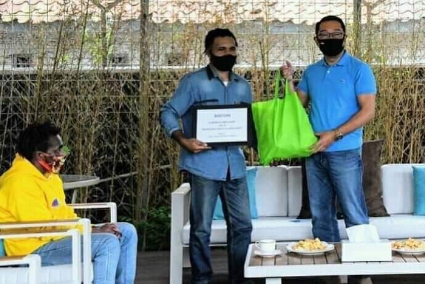 Gubernur Jawa Barat Ridwan Kamil saat menyerahkan bantuan kepada mahasiswa Papua