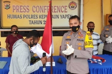 Noak Orarei, komandan kelompok kriminal bersenjata (KKB) Wilayah Distrik Kosiwo, Kabupaten Kepulaun Yapen, Provinsi Papua, saat mencium bendera merah putih, Rabu (17/3). [Foto: Humas Polres Yapen]