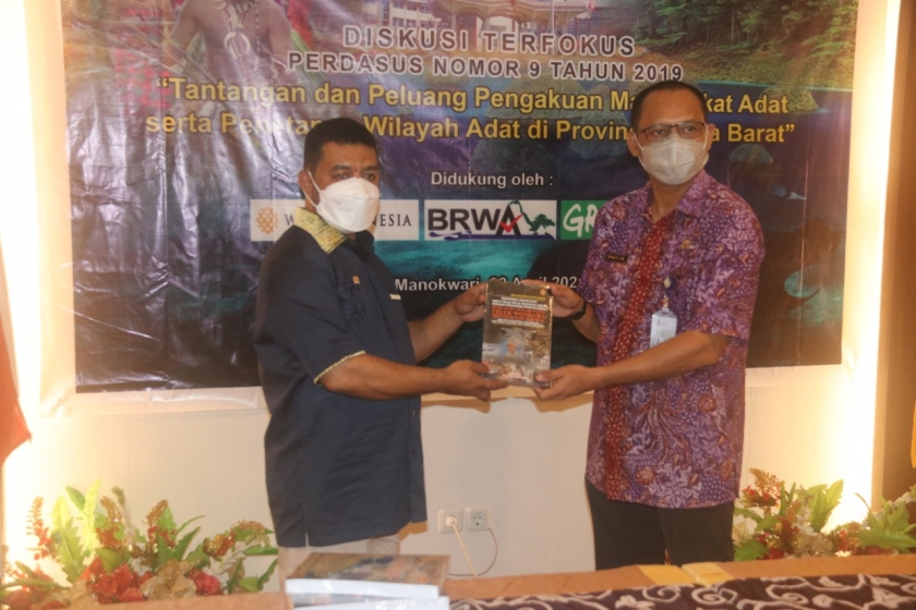 Senator DPD RI Dr. Filep Wamafma, SH., M.Hum saat menyerahkan 4 buku kepada Kepala Badan Penelitian, Pengembangan Daerah (Balitbangda) Provinsi Papua Barat, Prof. Dr. Charlie Denny Heatubun, S.Hut., M.Si pada Kamis (22/4). [Foto: JP/WRP]