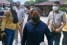 ES (19 tahun) terduga pelaku unggahan ujaran kebencian terhadap suku Arfak saat tiba di Mapolres Manokwari. [Foto: Kompas/Adlu Raharusun]