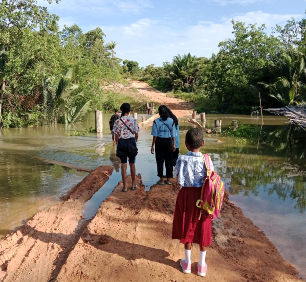 Potret masyarakat juga pelajar sulit melintasi jalan di Sumuri, Bintuni. [Foto: WRP]